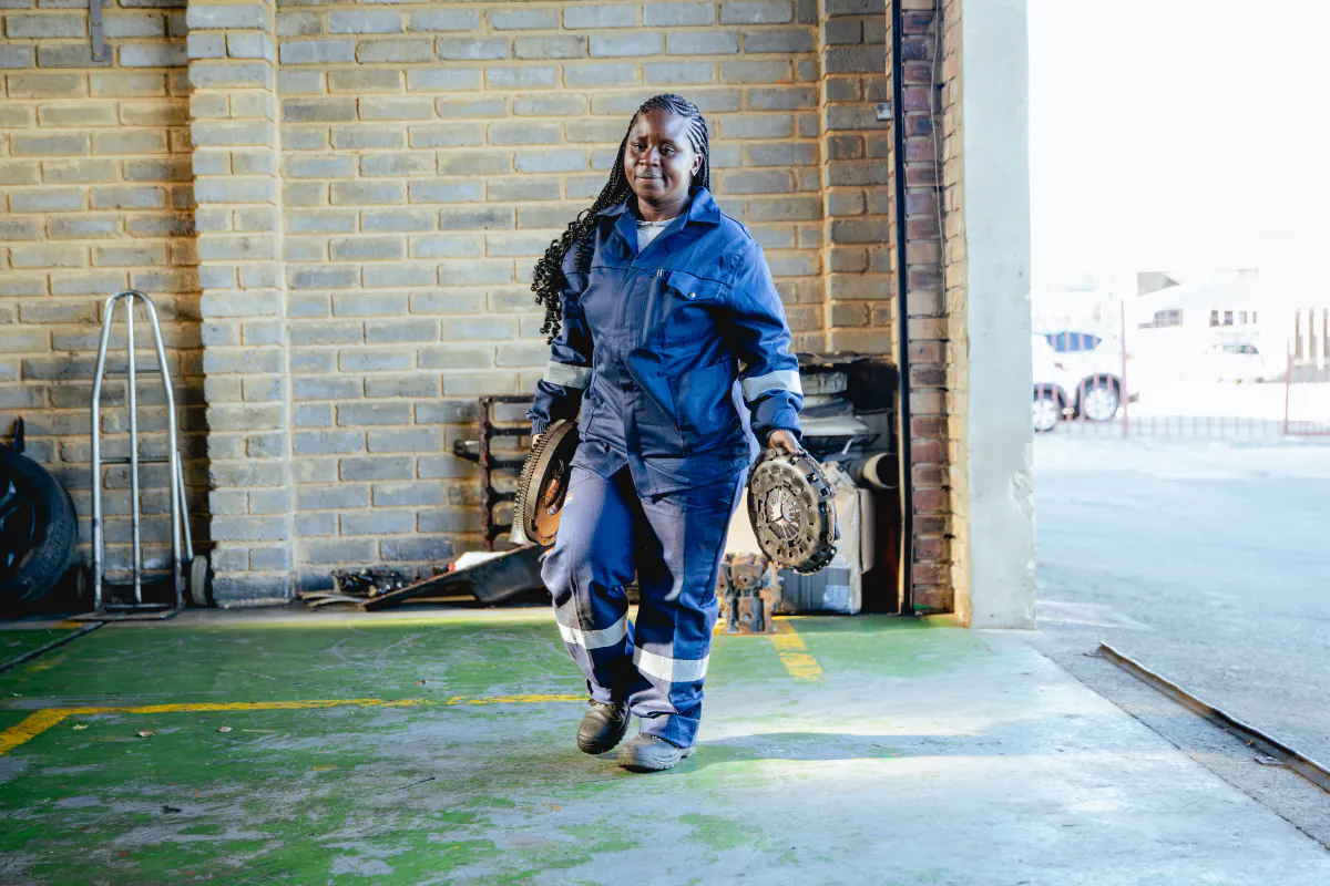Womech technician carrying clutch components